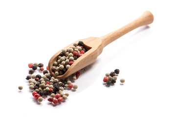 Close-up of pile of pepper seeds mix spice in a wooden spoon on white background