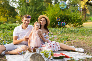 Joyful young family with little baby girl spending time together
