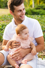 Happy young father playing with his little daughter