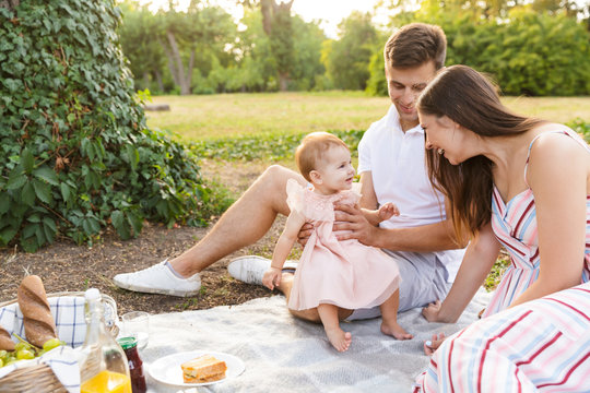 Positive young family with little baby girl spending time together