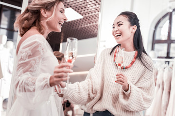 Important event. Delighted nice women drinking champagne while discussing a future wedding