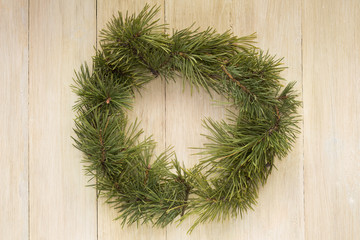 Christmas wreath with branches natural evergreen pines on wooden board with copy space. Flat Lay. Minimal style.