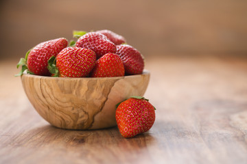 fresh ripe strawberries in wood bowl on table - Powered by Adobe