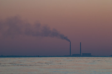 Smoke from the pipe at sunset, Power plant with huge smoke and electric towers in the distance, pollution concept,