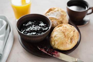 Simple breakfast: coffee americano, fresh buns with jam and juice.