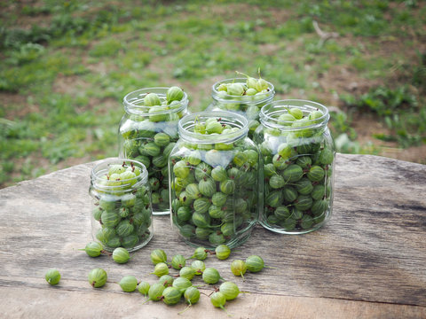 Green gooseberry berries in jars on the table