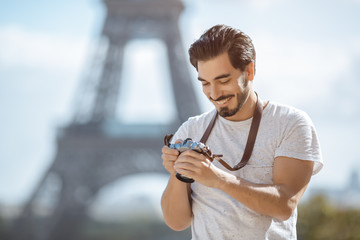 Paris Eiffel Tower tourist with camera taking pictures in front of the Eiffel tower, Paris, France....