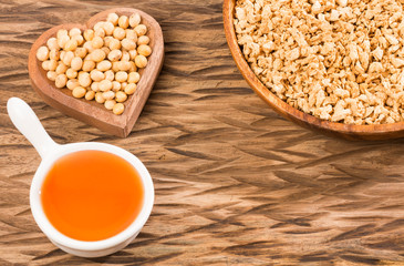 Oil and soybeans - Glycine max. Wooden background