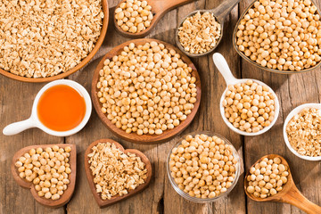 Oil and soybeans - Glycine max. Wooden background