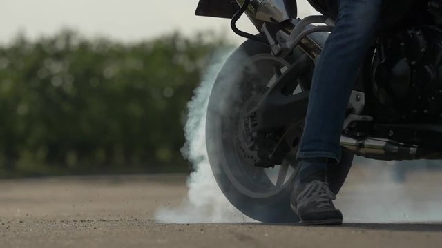 Motorbike burnout, Biker on a motorcycle drifts in smoke, burns tire on a motorcycle.