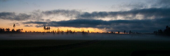 sunset and fog over field