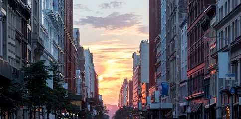Foto op Plexiglas Kleurrijke zonsondergang tussen de gebouwen van Midtown Manhattan in New York City © deberarr