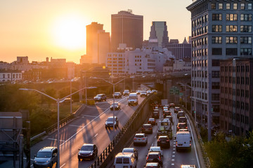 View of rush hour traffic on the Brooklyn Queens Expressway in New York City with sunset light in background