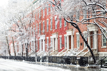 Snowy winter street scene with historic buildings along Washington Square Park in Manhattan, New York City