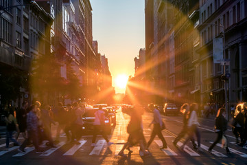 Sunlight shines over the buildings and people of a busy Midtown Manhattan street scene in New York...