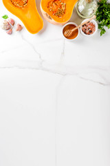 Halves of raw pumpkin or butternut squash, with olive oil, spices and ingredients for cooking 