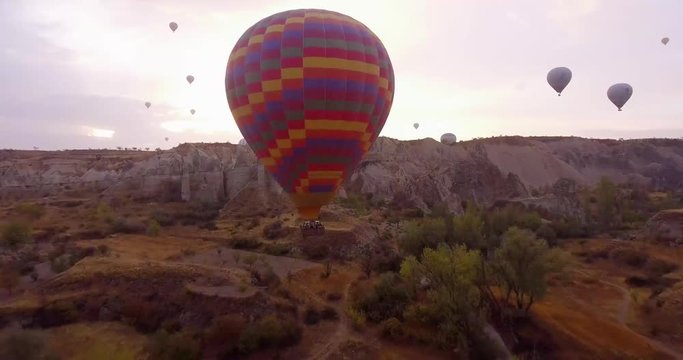 Cappadocia Valley of Love. Copter flies between picturesque rocks and balloons revealing the beauty of both.