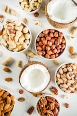 Various types of nuts - walnuts, pecans, peanuts, hazelnuts, coconut, almonds, cashews, in bowls