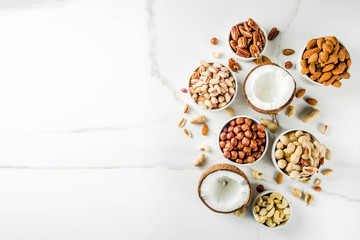 Various types of nuts - walnuts, pecans, peanuts, hazelnuts, coconut, almonds, cashews, in bowls