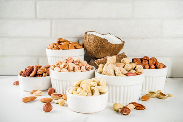 Various types of nuts - walnuts, pecans, peanuts, hazelnuts, coconut, almonds, cashews, in bowls