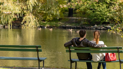 young couple sitting on a bench in the park