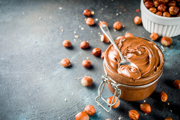 Breakfast confectionery and sweets concept. Homemade hazelnut chocolate spread in glass bowl with...