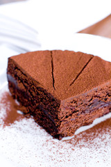 Piece of chocolate cake on white plate.