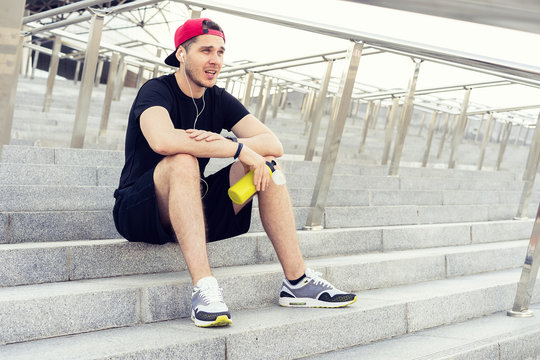 Young man resting on the stairs after running.