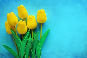 Artificial yellow tulips on blue background for nature decoration and springtime concept