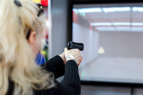 Woman shooting in virtual shooting gallery