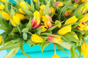 Floristics, holidays and flowers concept - a big bouquet of red and yellow tulips on blue background