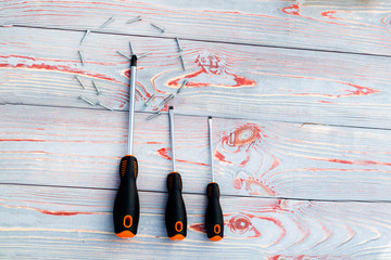 three screwdriver or one with screws in the shape of a circle. On a wooden background there are...