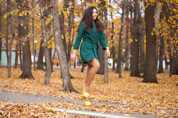Portrait of a young beautiful brunette woman in short green coat
