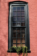 Fototapeta na wymiar Black framed window on red brick building