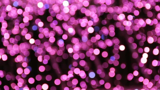 Abstract unfocused backgrounds with Christmas decorations with purple led light bokeh and white ligt comets. Pedestrian dark silhouettes walking