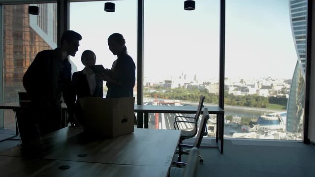 Several silhouettes of attractive handsome businesspeople interacting business center. Males and females contacting and cooperating with themselfs in glass modern business centre. Slow motion