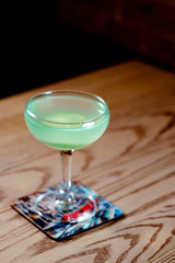 green and blue with lime alcohol cocktail in the glass on the table in bar