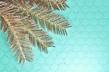 Pastel Blue , textured backdrop with glitter.  Shiny painted pine branch on left side of image.