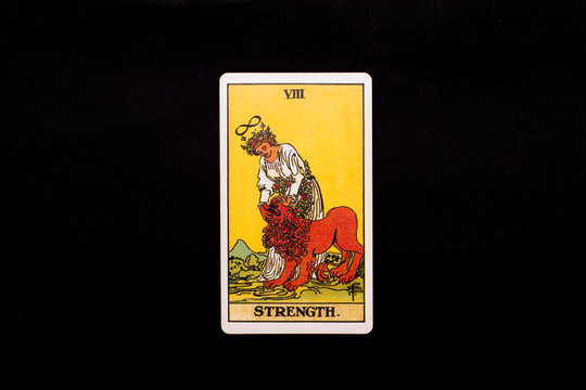 An individual major arcana tarot card isolated on black background. Strength.