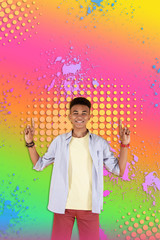 Stylish boy. Handsome stylish boy standing in front of colorful ground wearing dark red shorts and striped shirt smiling broadly