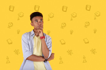 Clever student. Smart diligent student thoughtfully touching his face and imagining life after...
