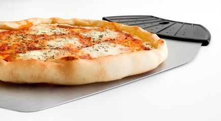 Detalle en primer plano de una pizza 4 quesos y utensilio para servirla 2