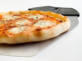 Detalle en primer plano de una pizza 4 quesos y utensilio para servirla