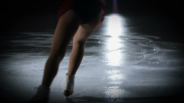 A talented perfomer jumps up in the air and makes one turn when she performs on the ice.