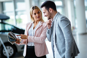 Dealer showing a new car model to the potential customer
