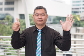 happy old man pointing up six fingers; retired pensioner counting, numbering with finger point; senior old man points six fingers up portrait; southeast old senior man model