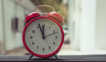 Red alarm clock on a wooden table.