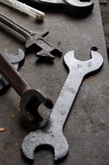 Vintage metal wrenches and tools on metal workbench 