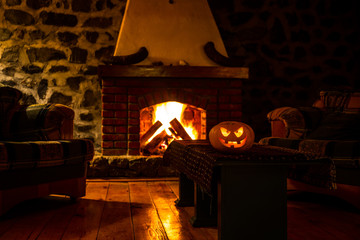 Creepy halloween pumpkin near a fireplace. Fire on the background.