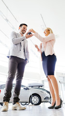Portrait of beautiful saleswoman standing inside vehicle showroom